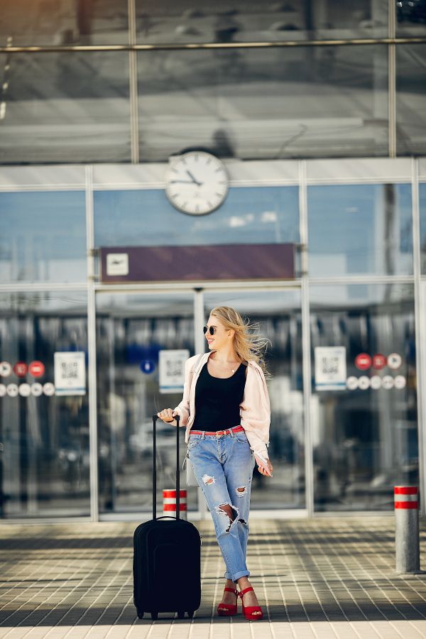 hermosa chica de pie en el aeropuerto 600